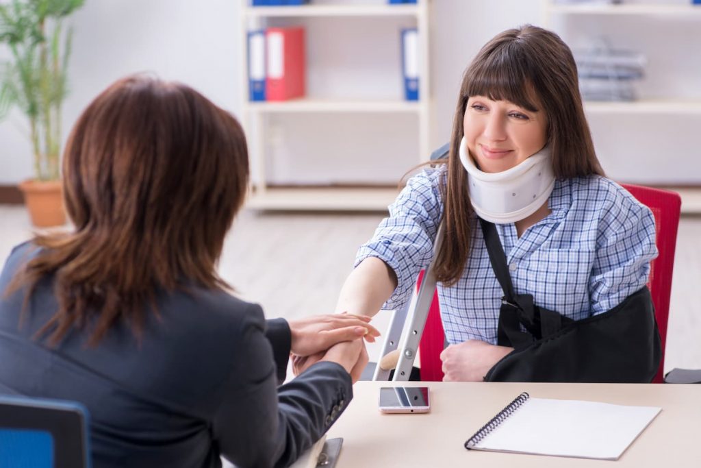 Female with a shoulder Sling talking to a doctor
